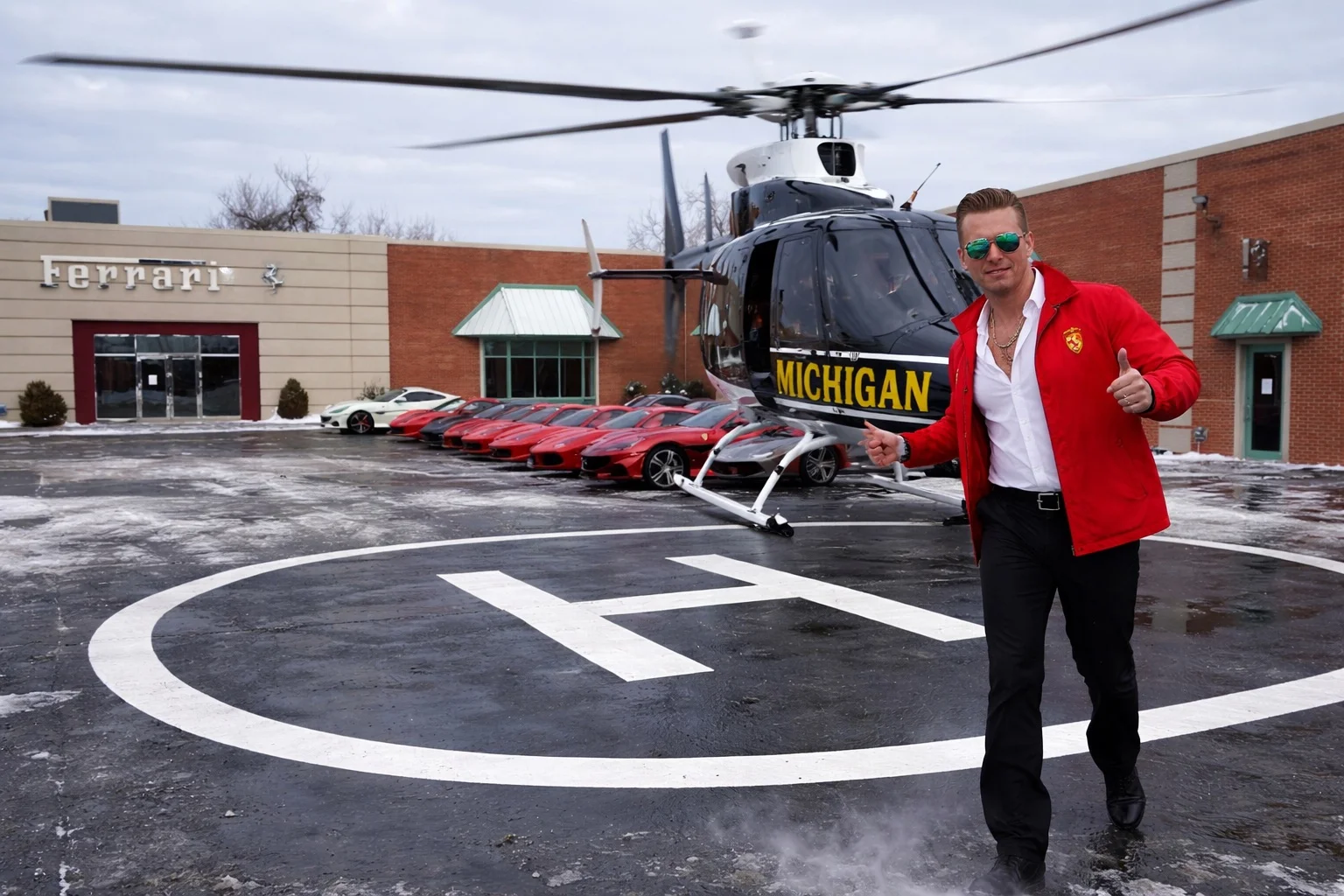 Man in Ferrari jacket stepping off a helicopter on a helipad at the Ferrari dealership